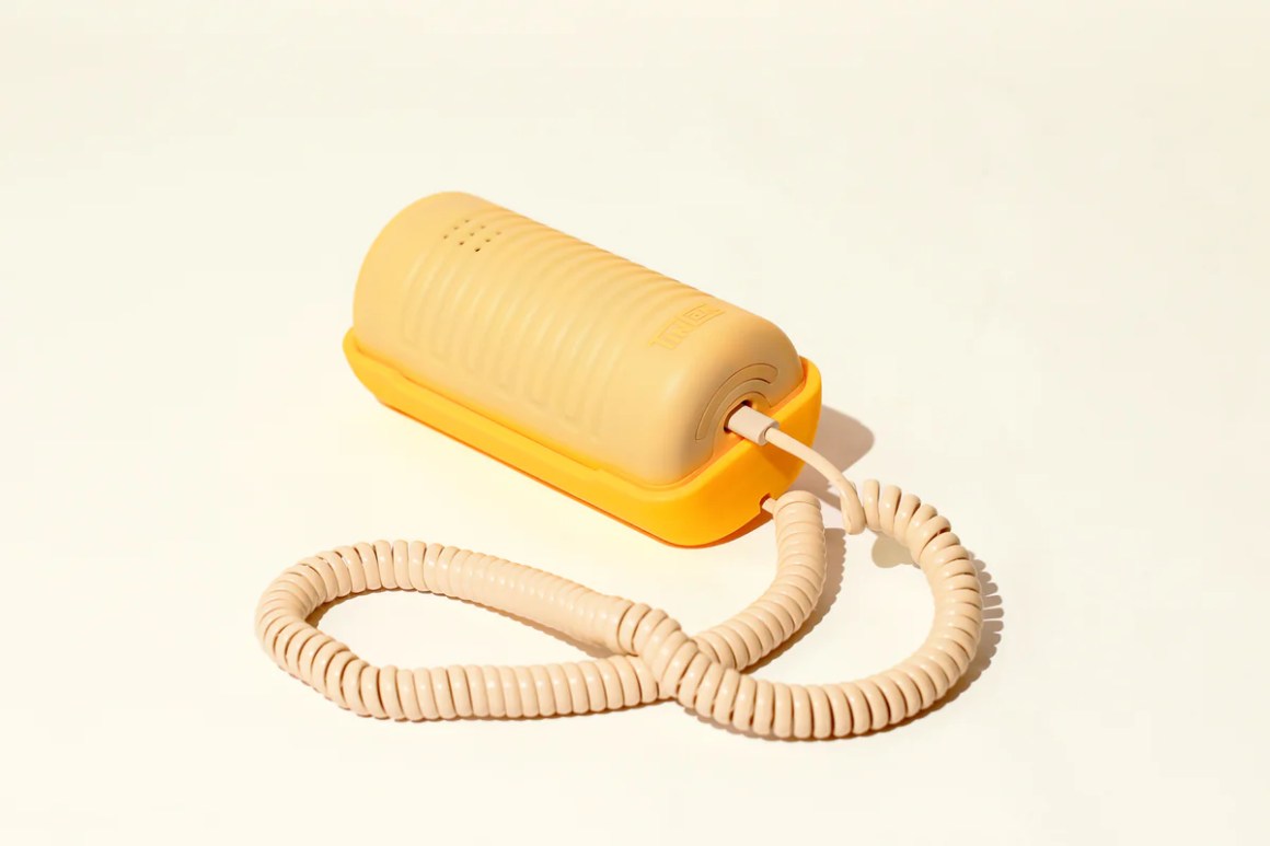 A retro, modern VoIP landline phone for kids in a playful yellow and beige design, featuring a corded handset and a coiled cable.