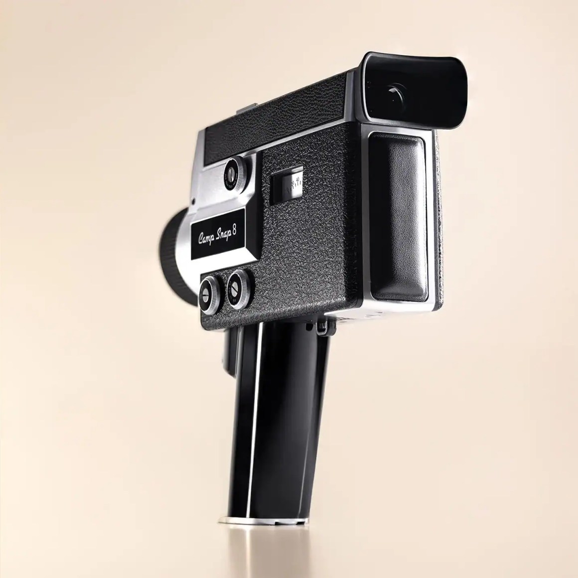 A vintage Super 8 film camera with a sleek black design, positioned against a light-colored background.