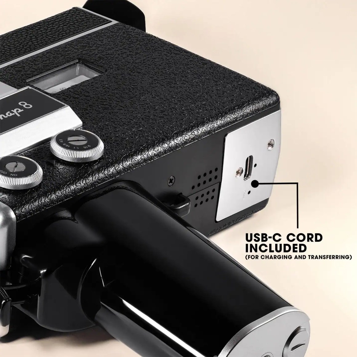 Close-up of a black retro film camera showing control knobs, a USB-C port for charging and transferring, and the 'Snap 8' label.