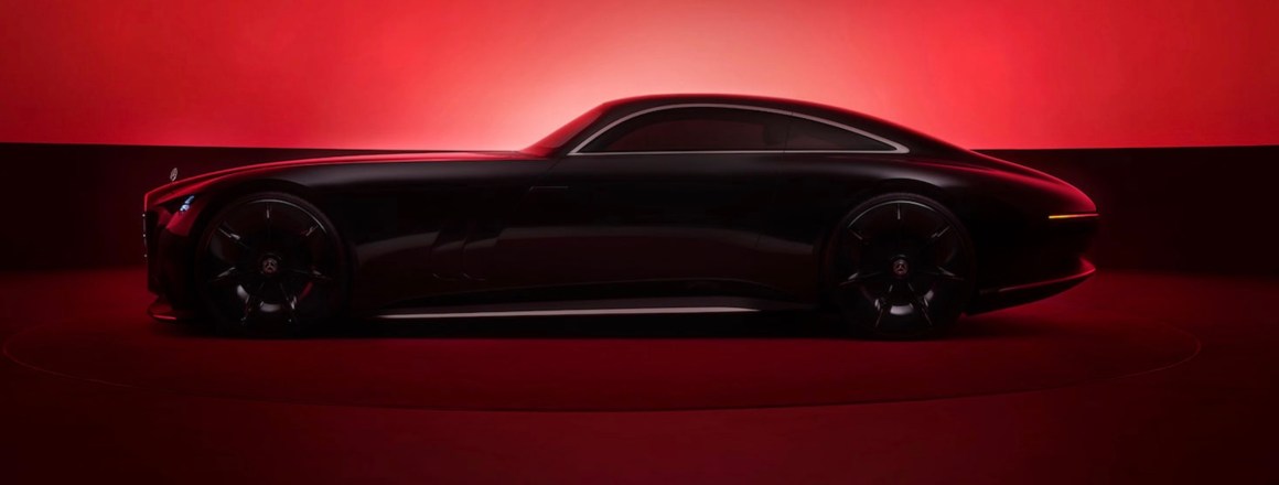 Side view of the Mercedes-Benz Vision Iconic concept car, showcasing its sleek silhouette against a red background.