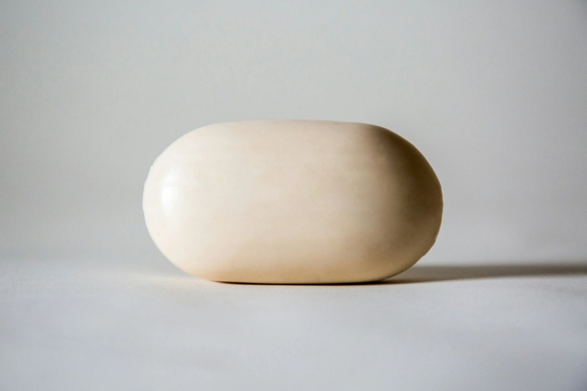 A smooth, oval-shaped bar of soap on a neutral background.