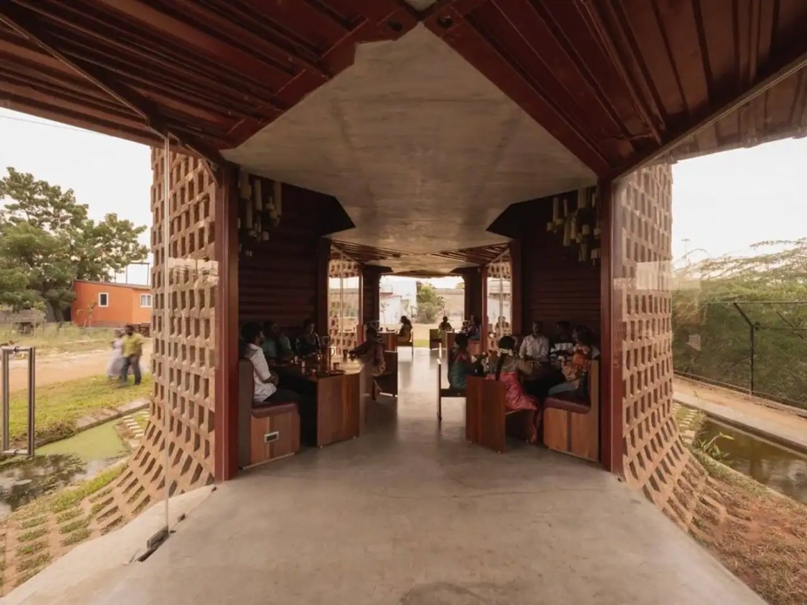 Interior view of a contemporary restaurant featuring an open design with geometric patterns and a blend of natural elements, showcasing guests seated at wooden booths.